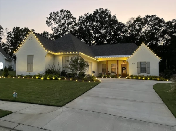 White home in Canton MS with christmas light installation at dusk